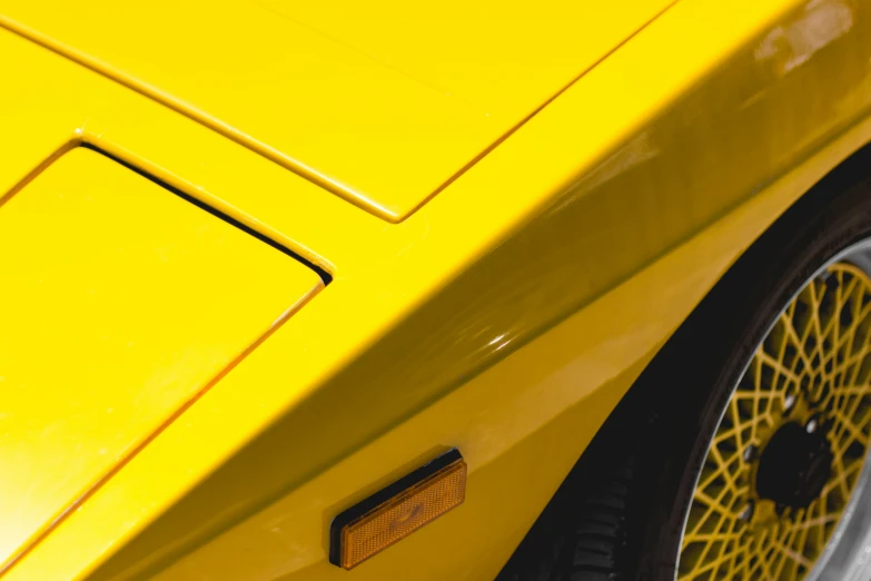 a yellow car is parked next to another car