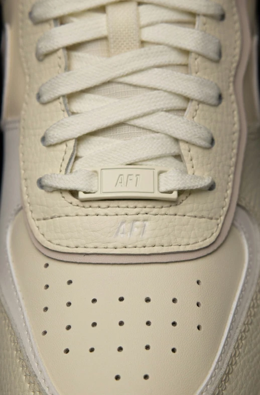 a white tennis shoe with no laces and a gray sole