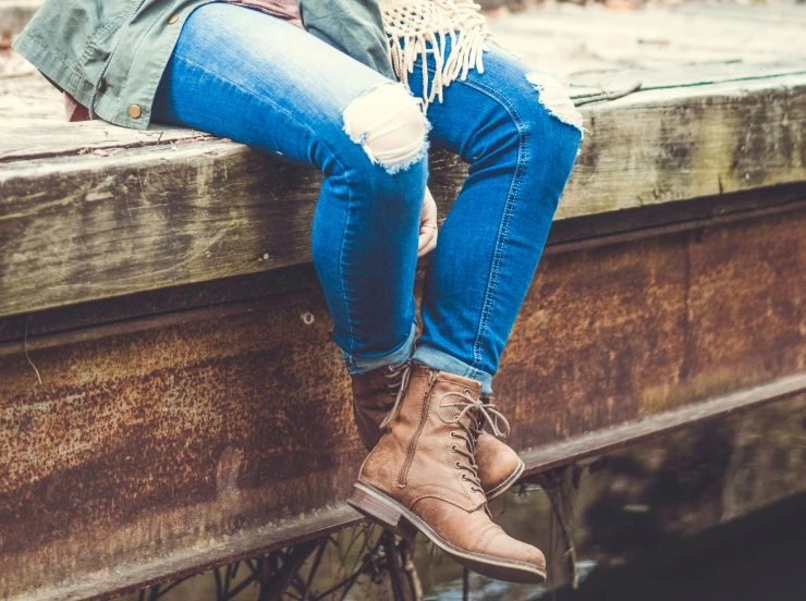 the legs of two people sitting on top of a bench