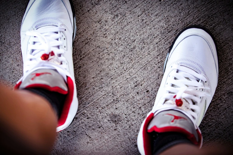 a white tennis shoe with a red stain on the bottom