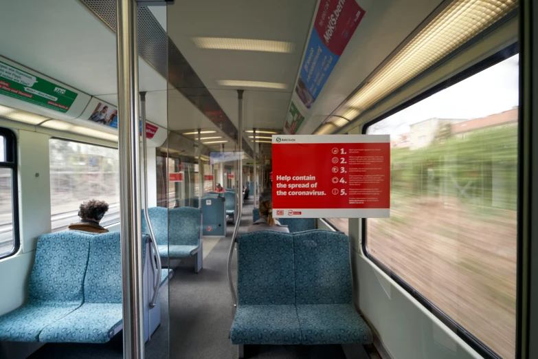 an empty train car sitting with seats and a view out the window