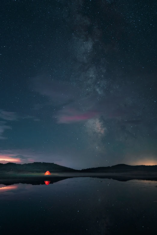 a body of water at night with many stars overhead