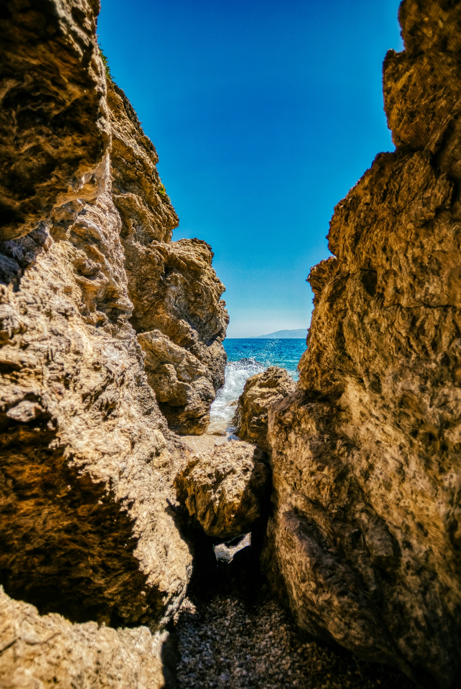 this is a view of a narrow rocky path between two large rocks