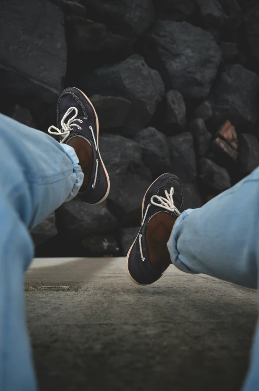 two shoes standing on a rock face each other