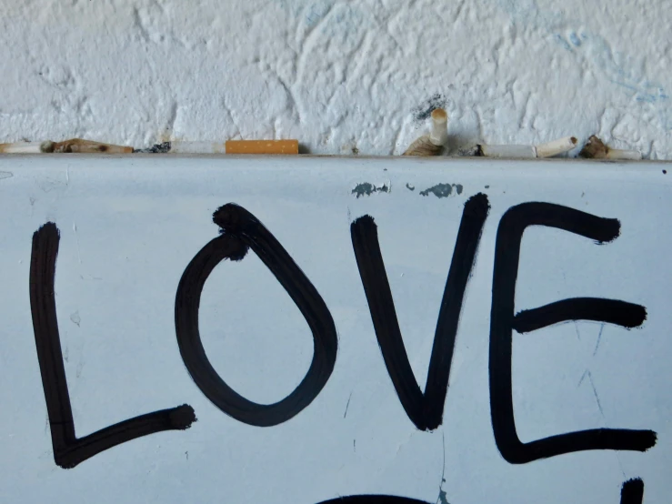a sign that has the word love written in black on it
