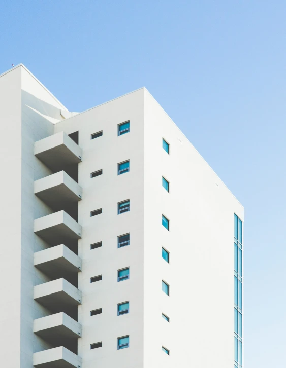 a very tall building that is white and has balconies on top