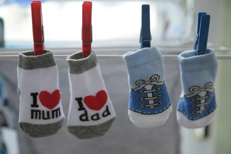 five pairs of socks hang from a clothes line