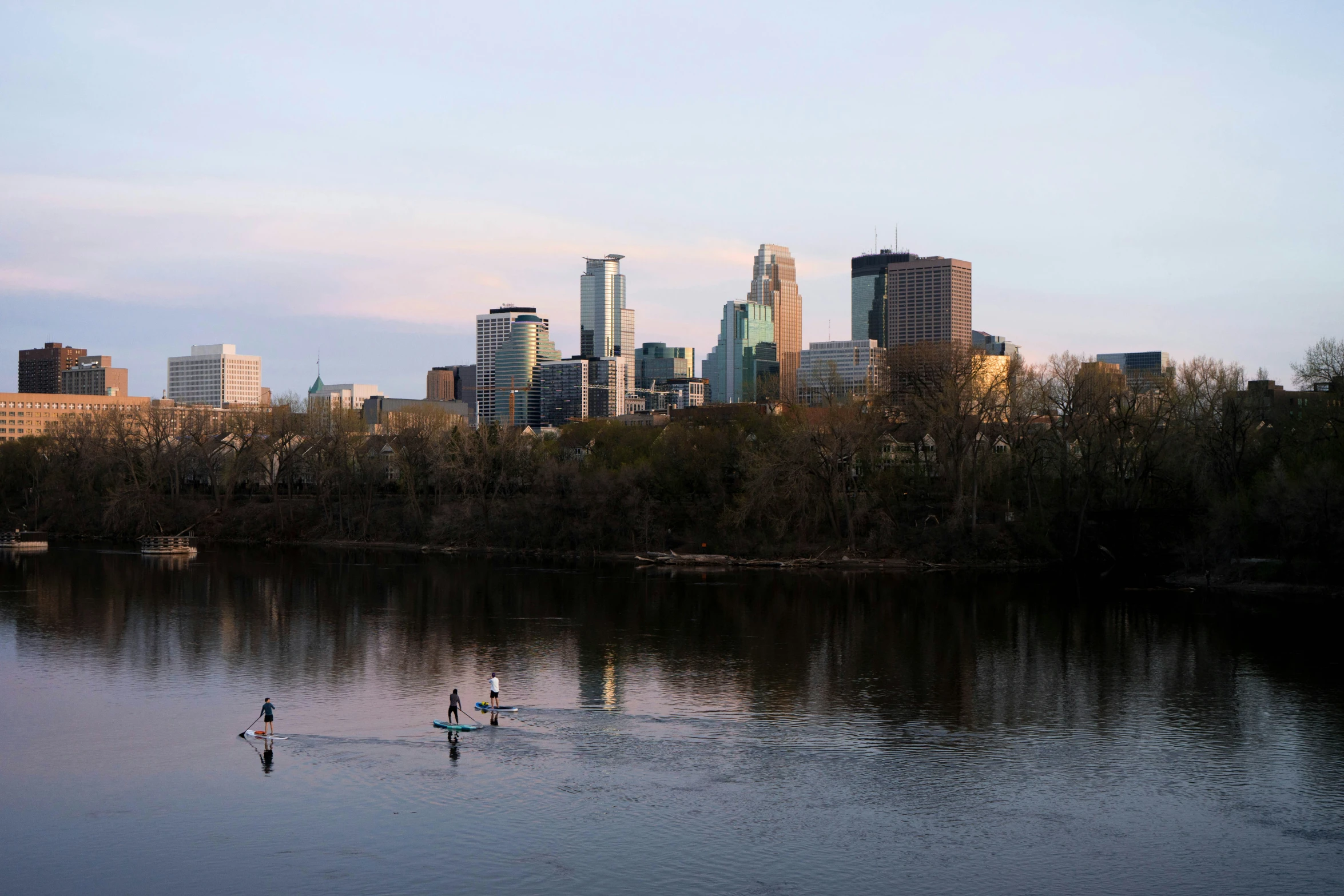 two people in a canoe with a city skyline in the distance