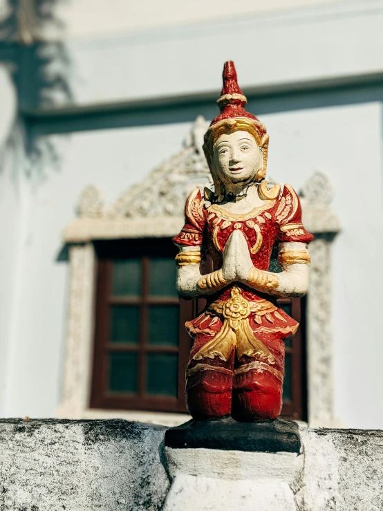 a small buddha statue is placed next to the window