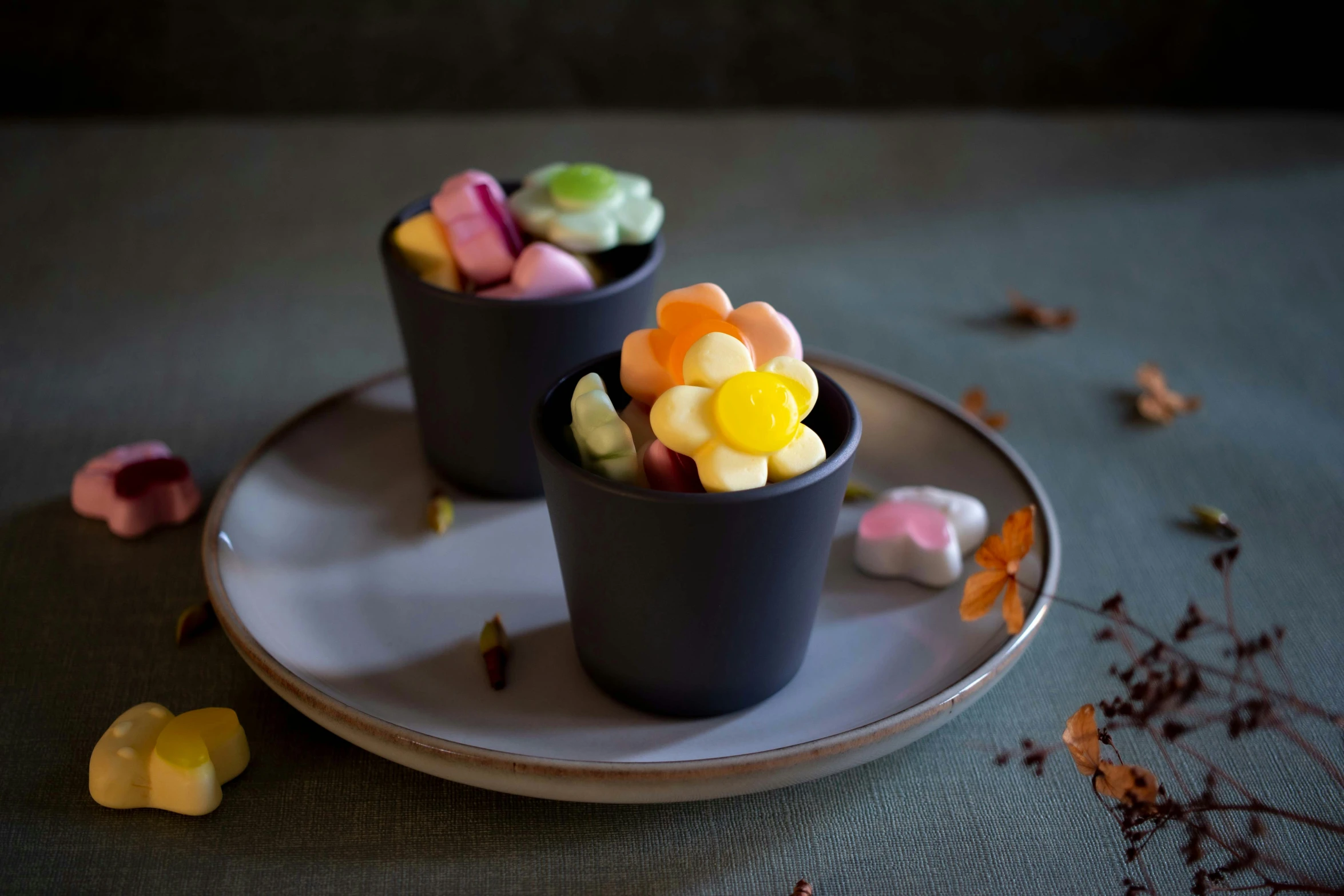 two cups filled with candy sitting on top of a plate