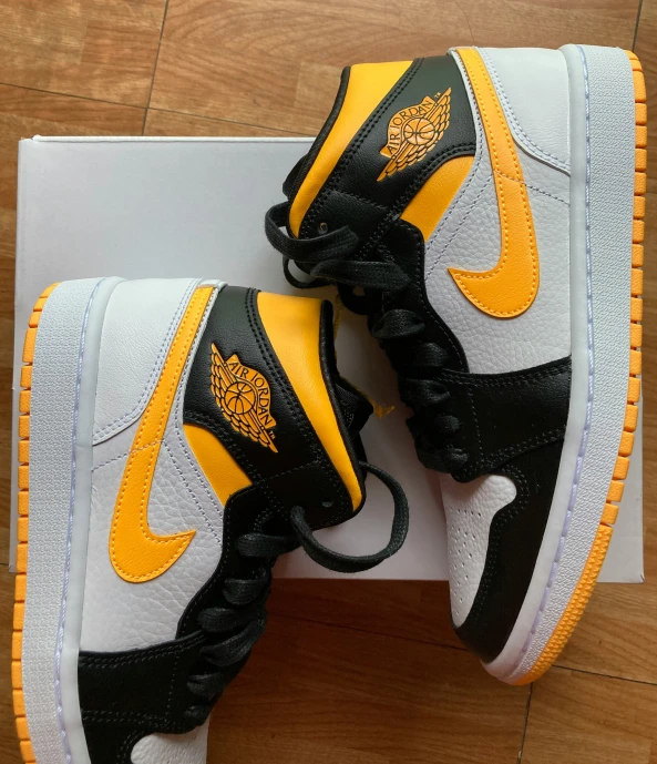 the yellow and black sneakers are displayed on the box