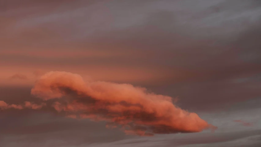 clouds are flying in the sky behind a jet airplane