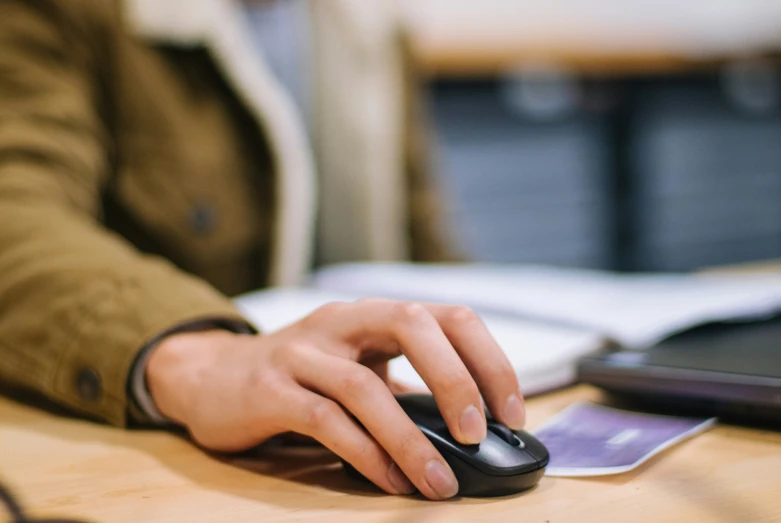 a person is typing on a mouse at a desk