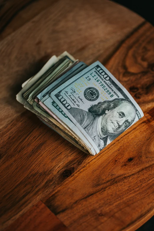 a stack of dollar bills sitting on top of a table