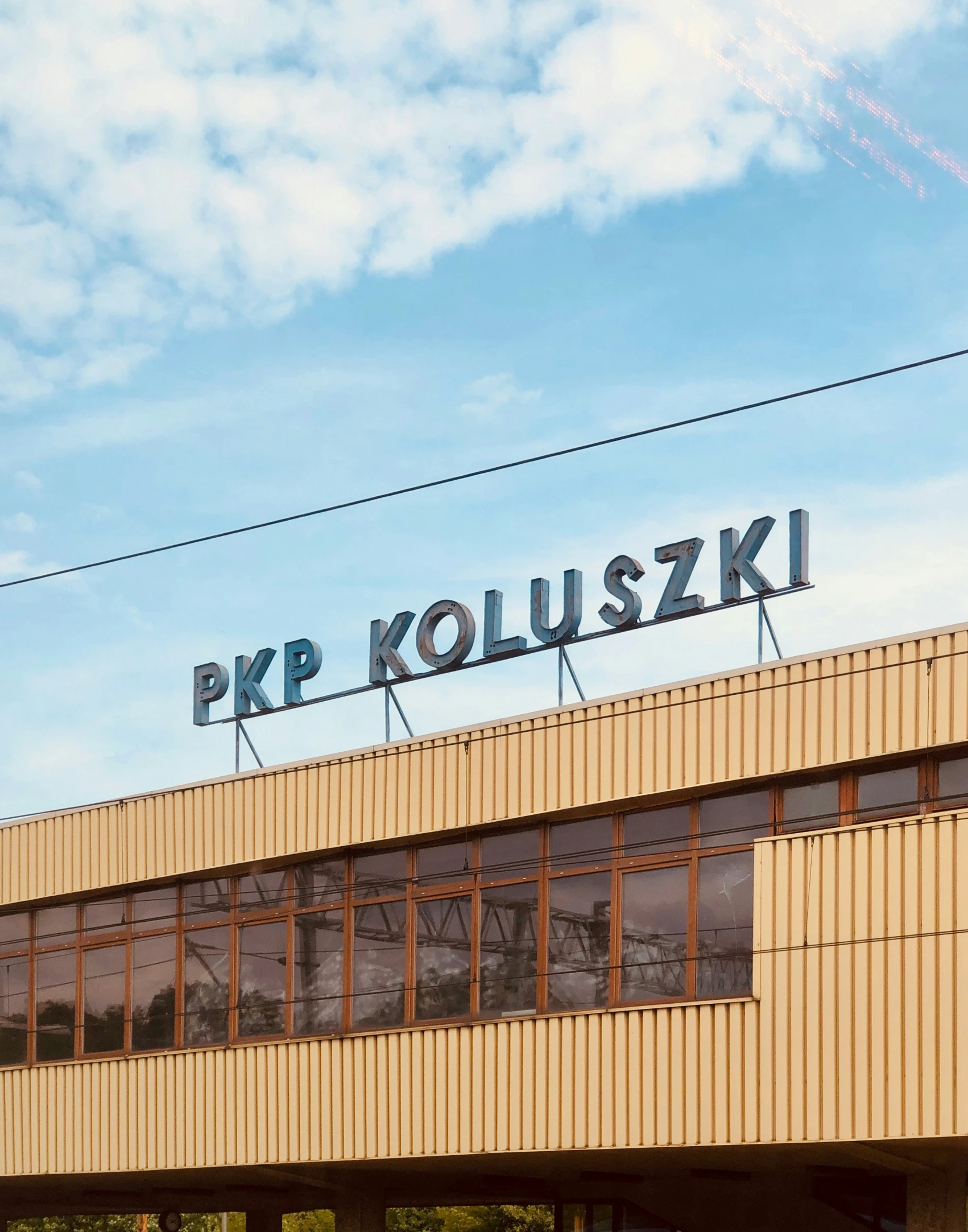 a large sign above an empty building near power lines