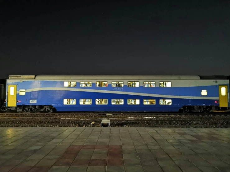 a blue and yellow train parked next to a train station