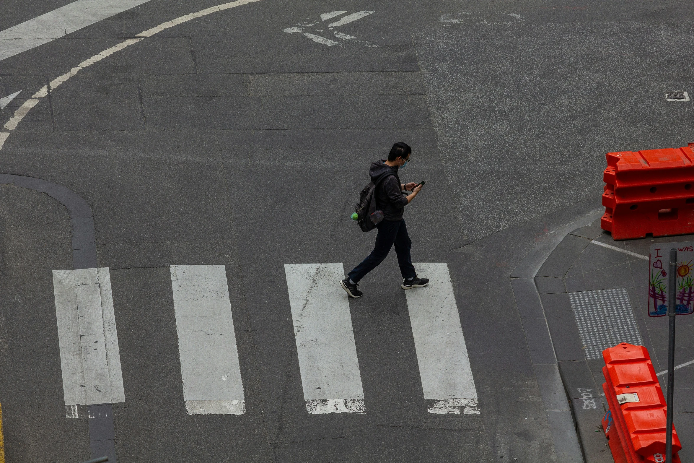 a person is walking on the street near some barriers