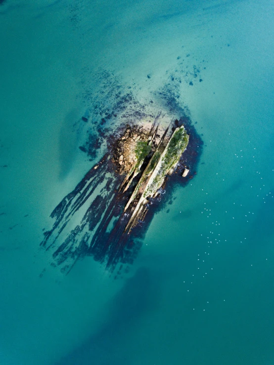 aerial s of a sea and island surrounded by small rocks