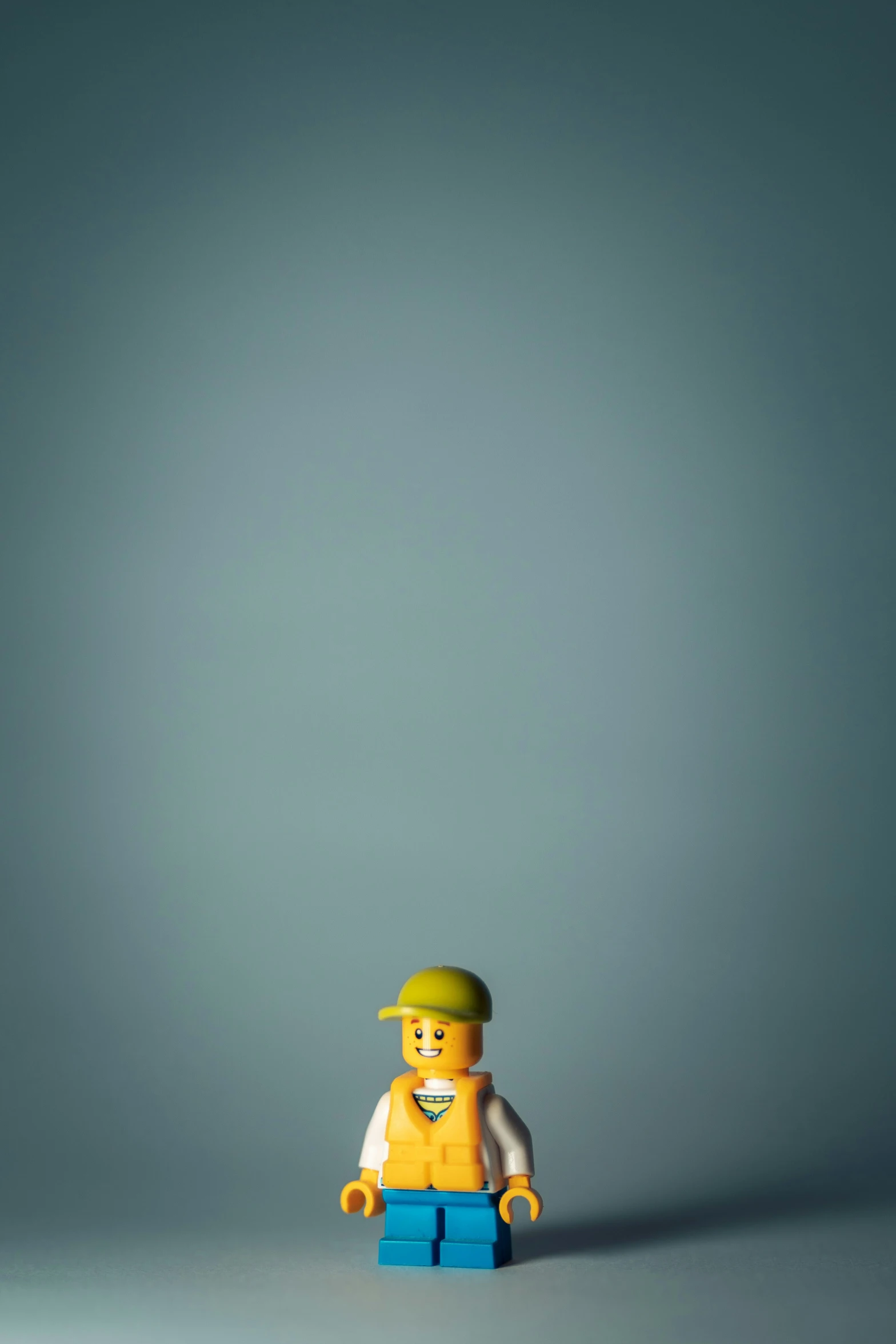 a lego figure standing on the ground wearing a yellow shirt