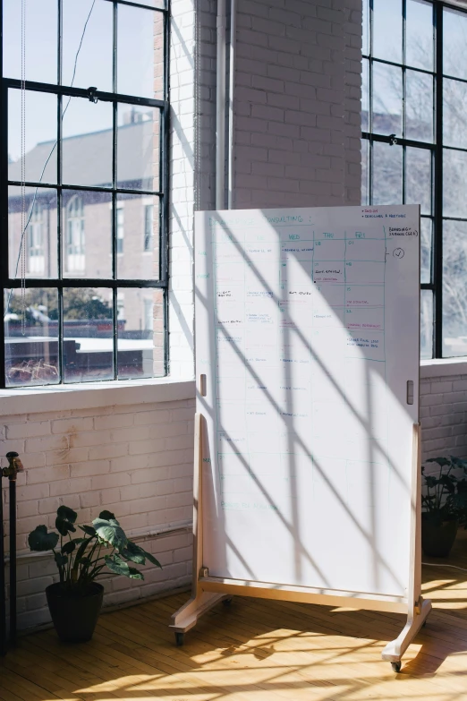 a whiteboard in front of a window with writing on it