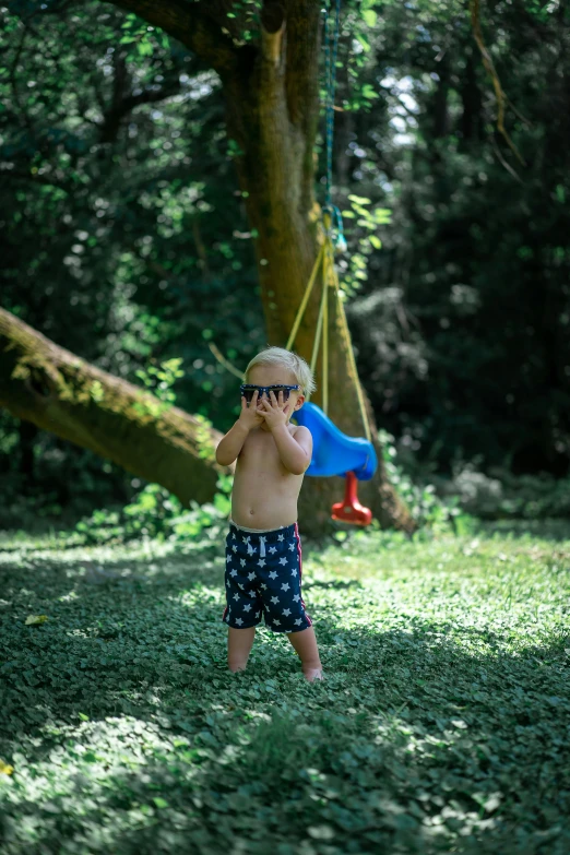 a boy with sunglasses on is holding his cell phone to his ear