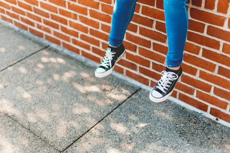 a person hanging upside down by a brick wall