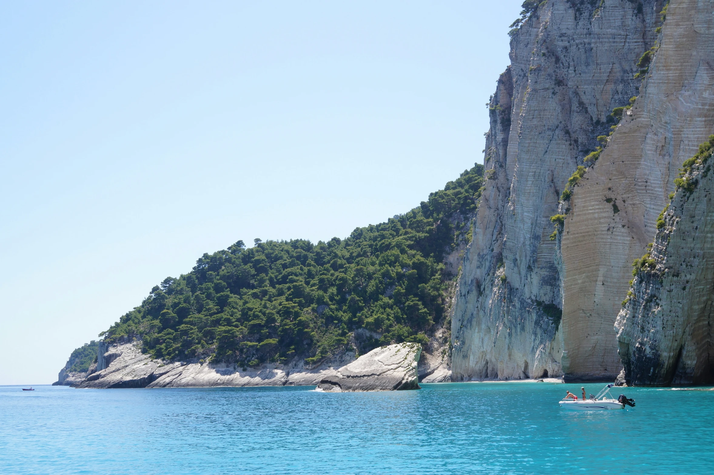 a man is on a kayak near the cliffs