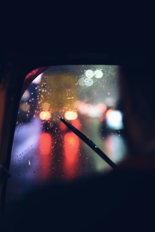 a man driving a car down a rain soaked street