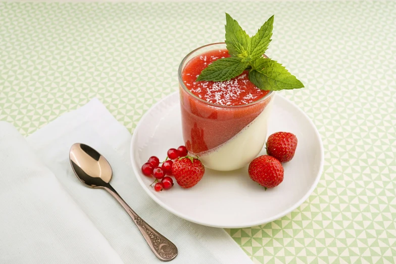 a plate with a drink and raspberries on it