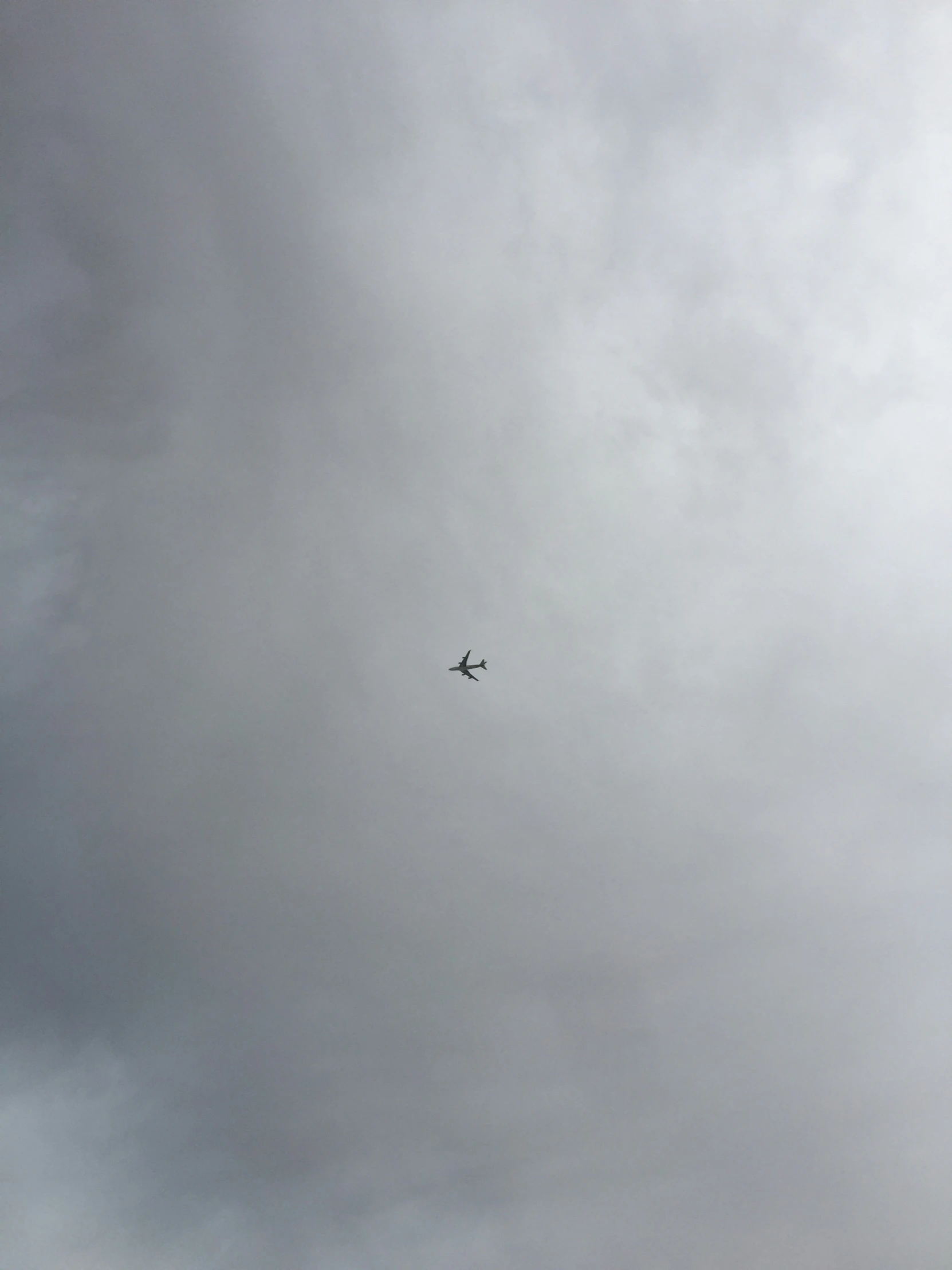 an airplane is flying in the cloudy sky