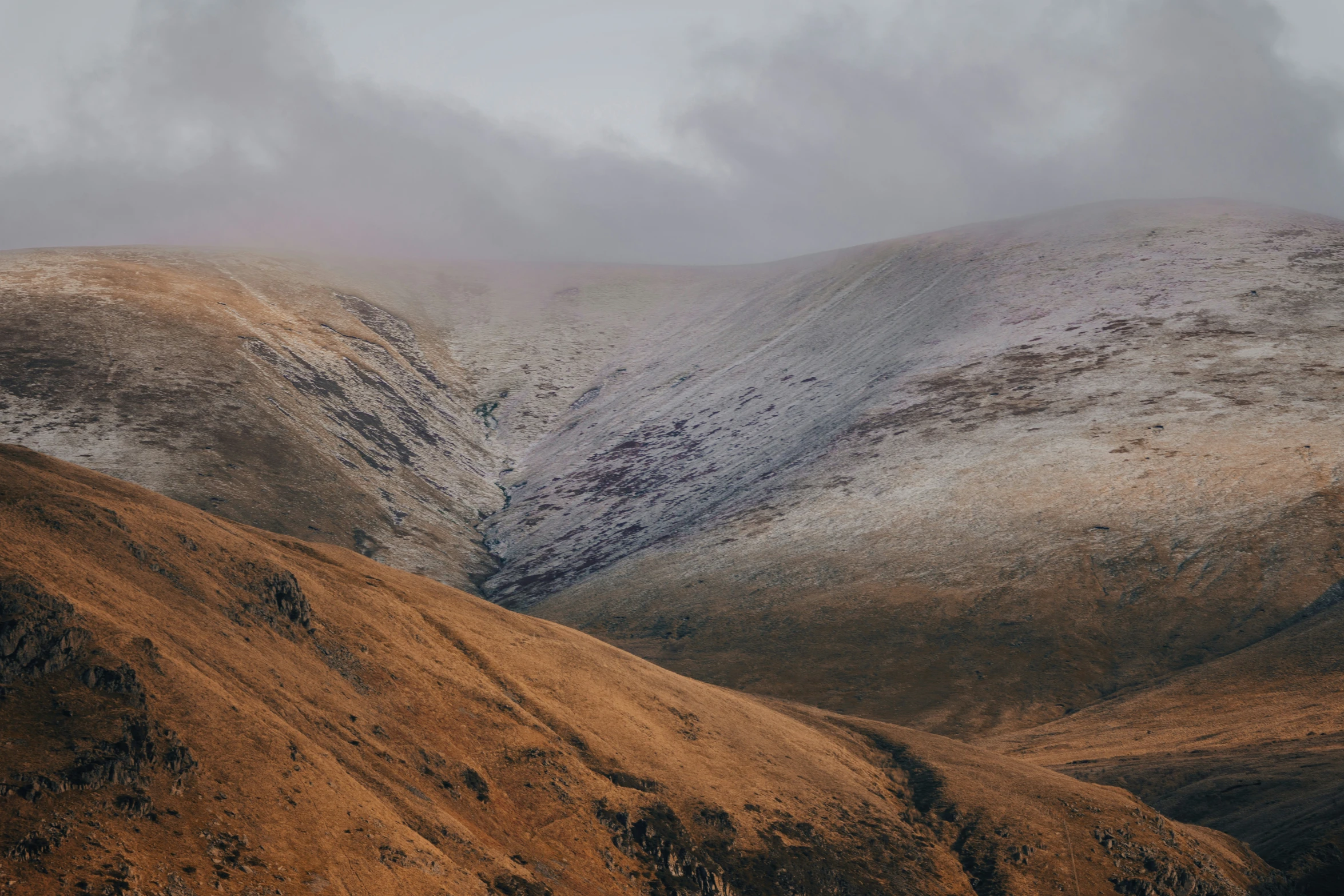 snow covered mountains sit beneath cloudy skies