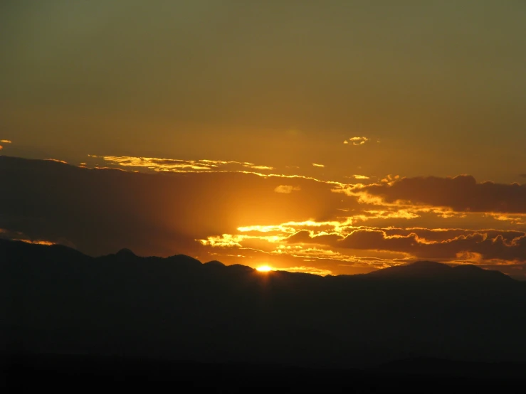 a very bright sun setting over the mountains