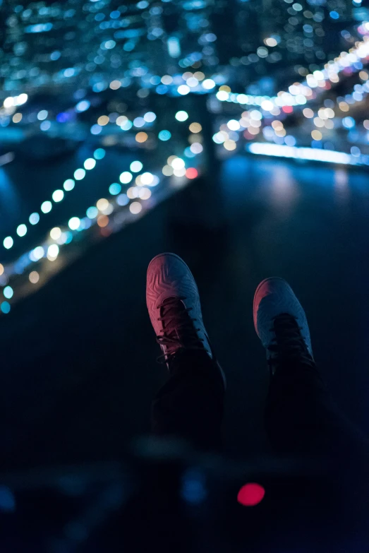 the foot of someone in sneakers with a city skyline in the background