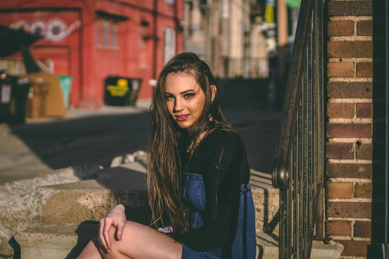 a beautiful young woman sitting on the steps with long hair