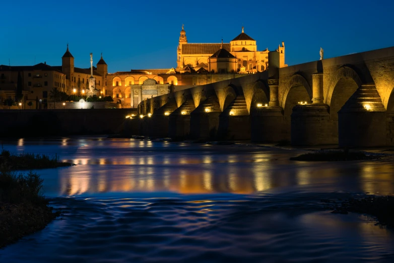 a city scene with the lights on and an arched building