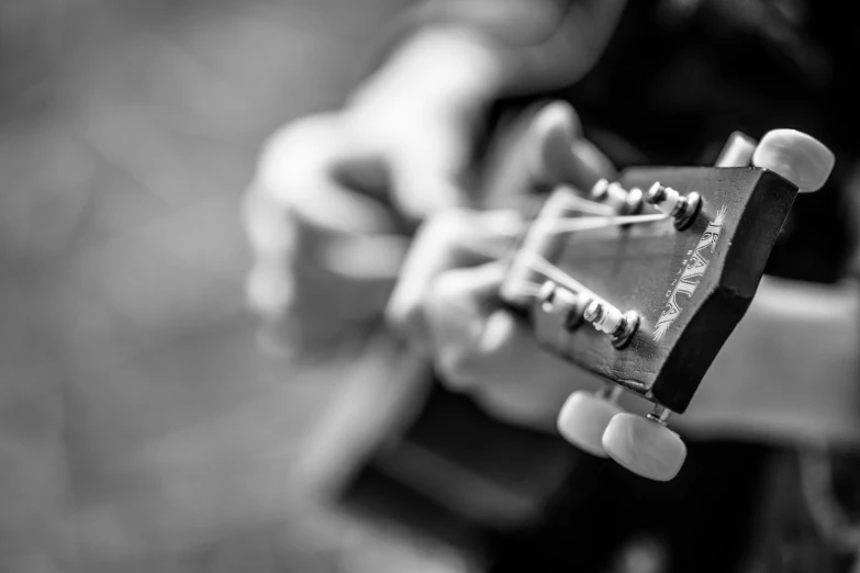 a person playing an acoustic guitar in black and white