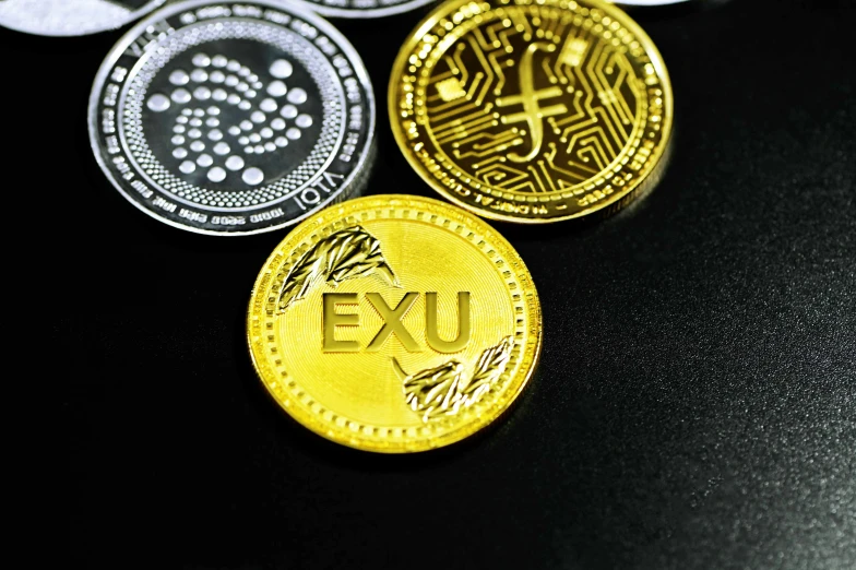 three different coin styles with the letters exu