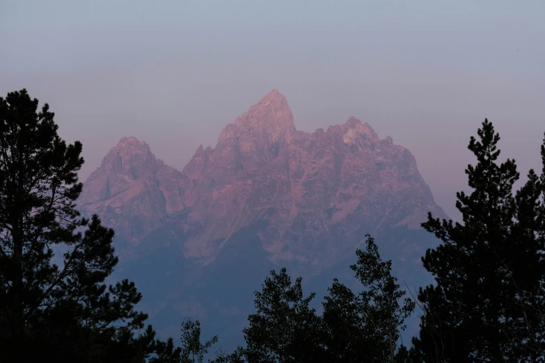 view of mountains and trees as the sun is setting