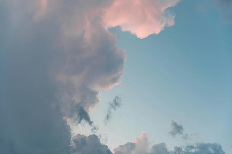 a large airplane in the sky with clouds behind it