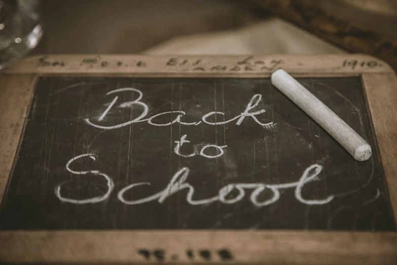 a chalkboard with writing back to school and a pencil