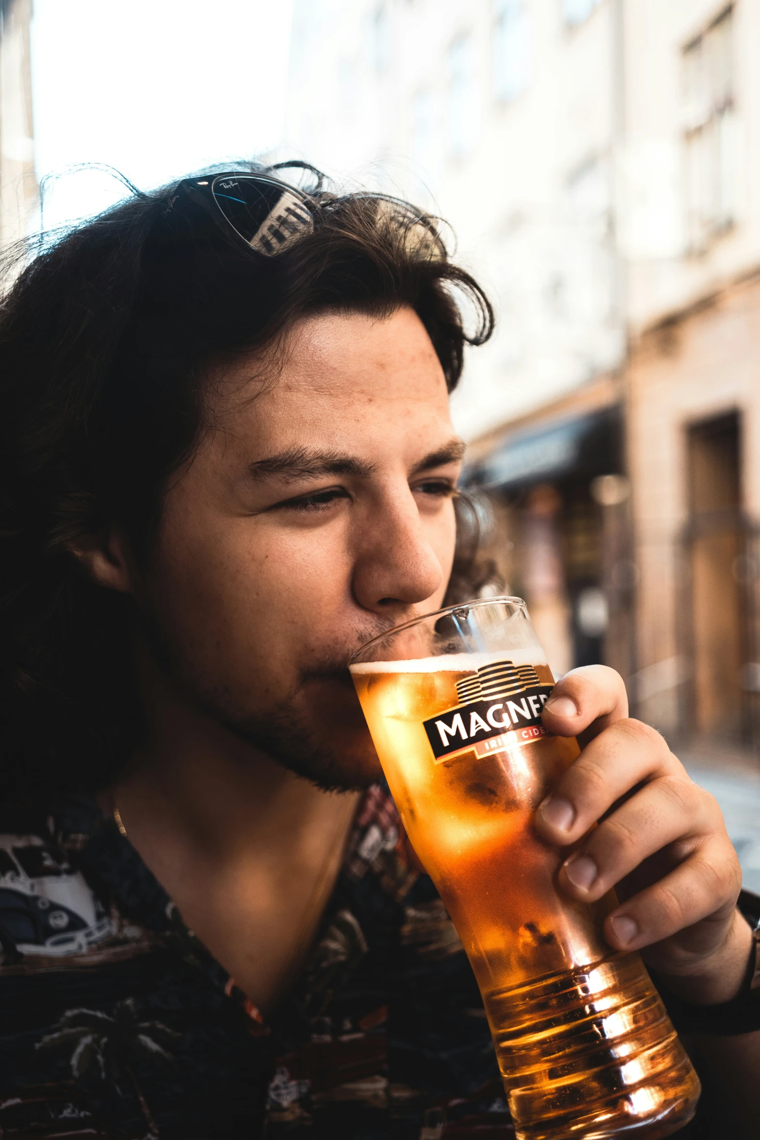 a young man drinking from a tall glass