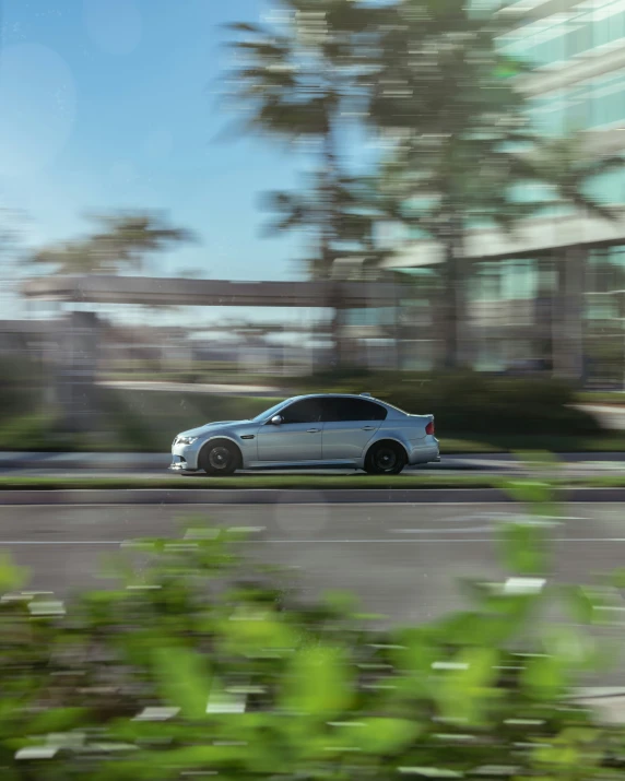 a car driving down a city street with tall buildings behind it