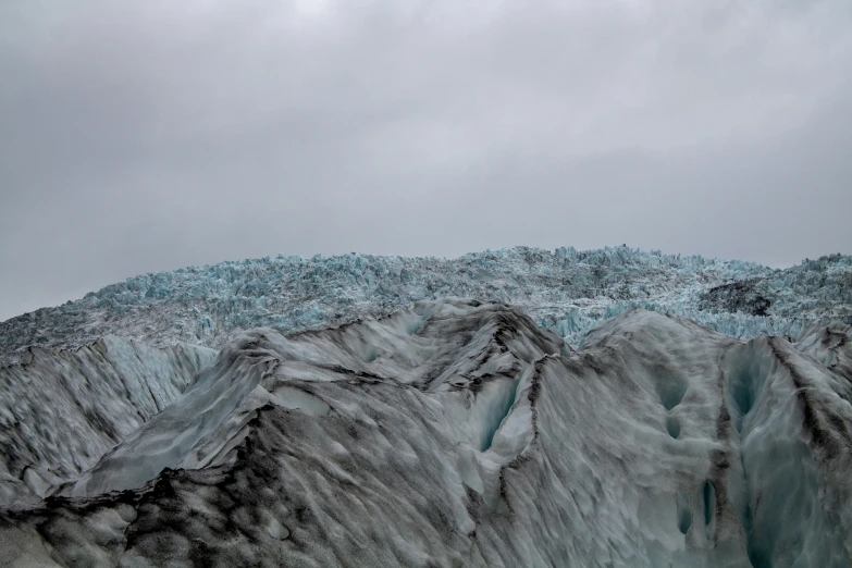 an aerial view of a large glacier with blue ice formations on it