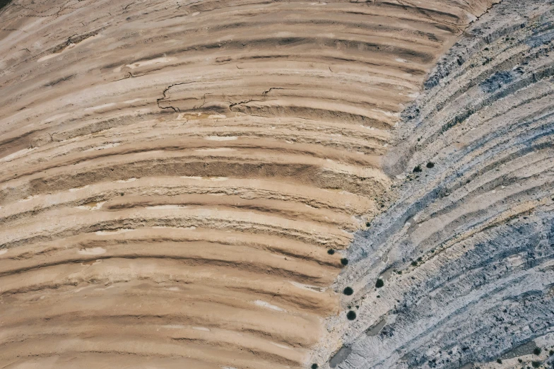 some sand and a hillside with grass and dirt