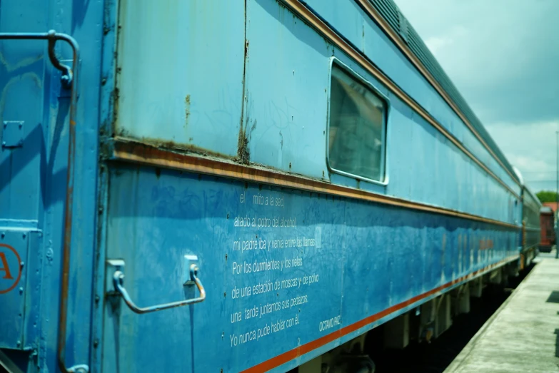 a blue train caboose is on a railroad track