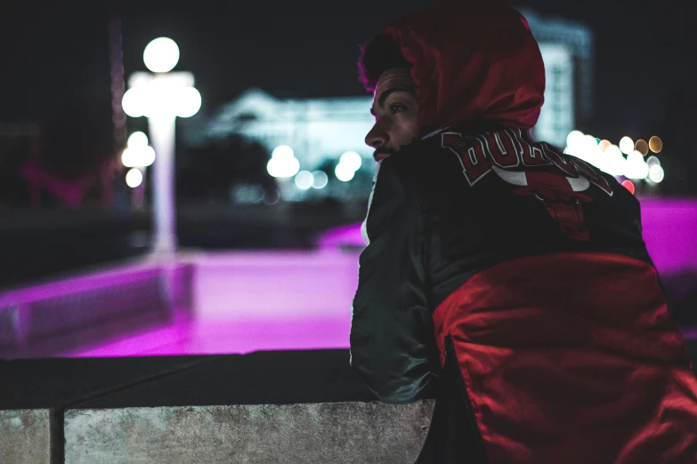 a man that is wearing a red hoodie looking at soing