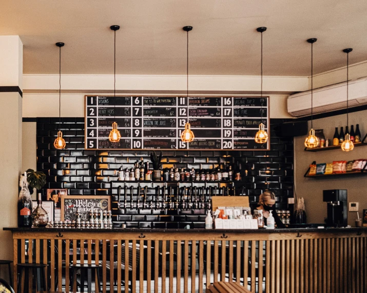 the inside of a coffee shop with lights hanging from the ceiling