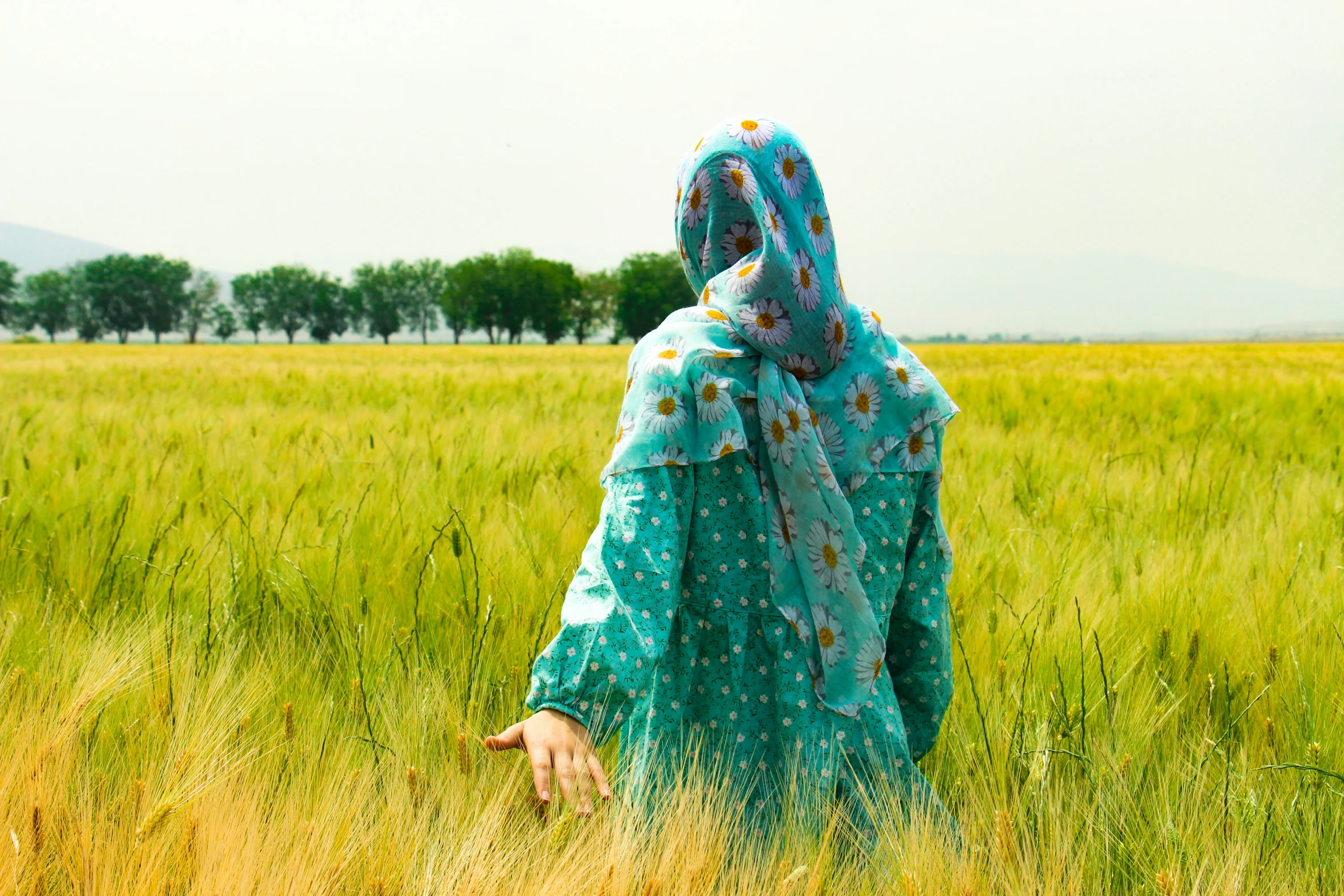 a person with a veil on and in a field of grass