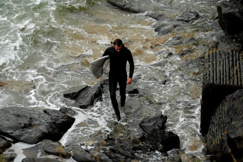 the man has a surfboard on his shoulders in the water