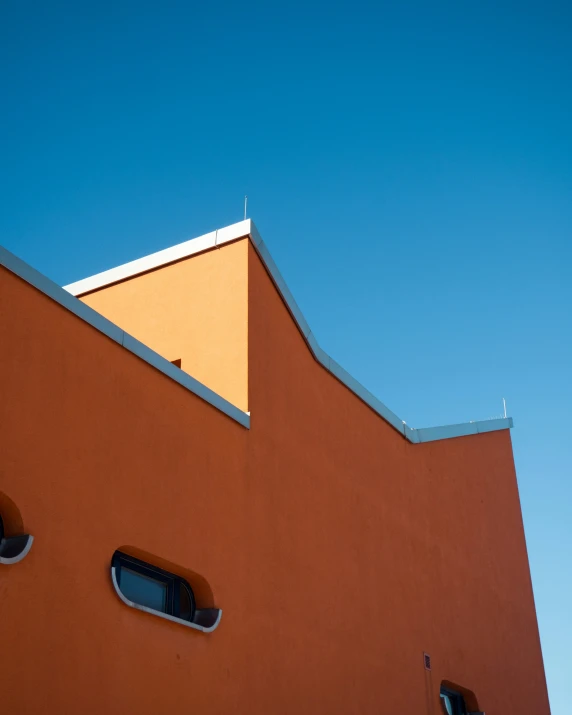 the side of a building with three windows on the outside